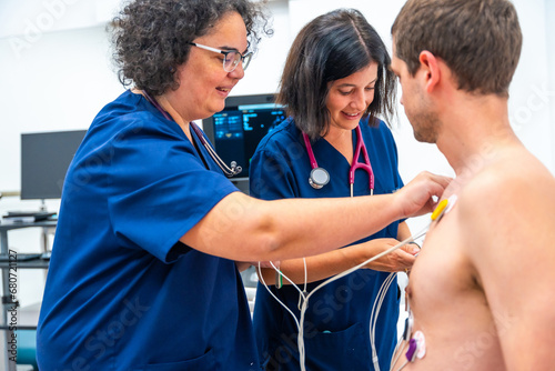 Cardiologist placing electrodes on a patient for a stress test photo