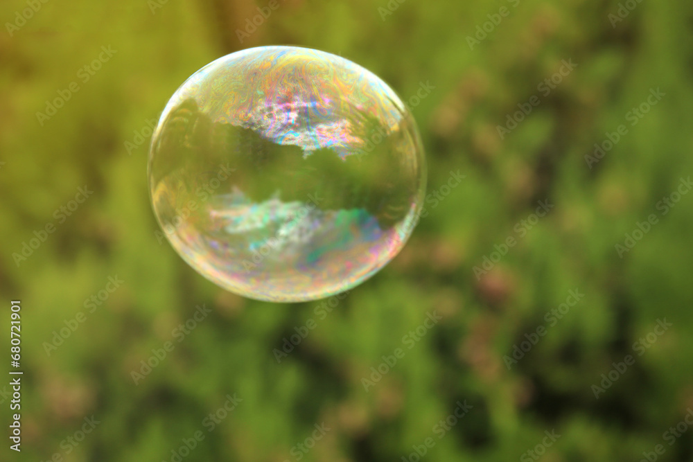One beautiful clear soap bubble floating outdoors