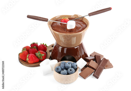Fondue pot with melted chocolate, berries, marshmallows and pieces of chocolate bar isolated on white