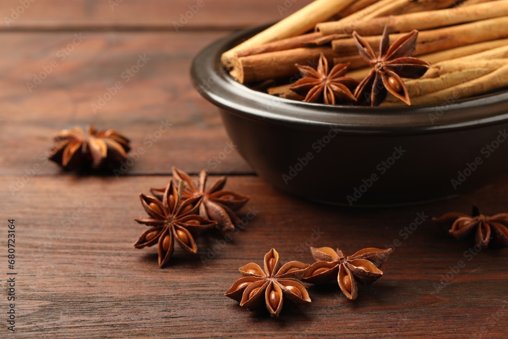 Bowl with cinnamon sticks and star anise on wooden table, closeup Bowl with cinnamon sticks and star anise on wooden table, closeup