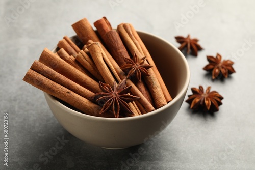 Bowl of cinnamon sticks and star anise on grey table