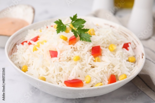 Fototapeta Naklejka Na Ścianę i Meble -  Bowl of delicious rice with vegetables and parsley on light table, closeup