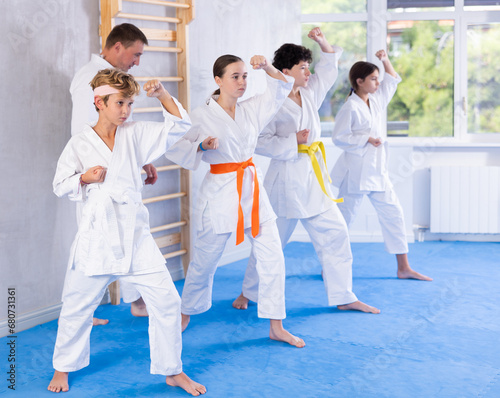 Group of karate kids practicing karate technique in gym