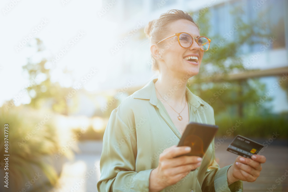 happy female worker in green blouse and eyeglasses using phone happy female worker in green blouse and eyeglasses using phone