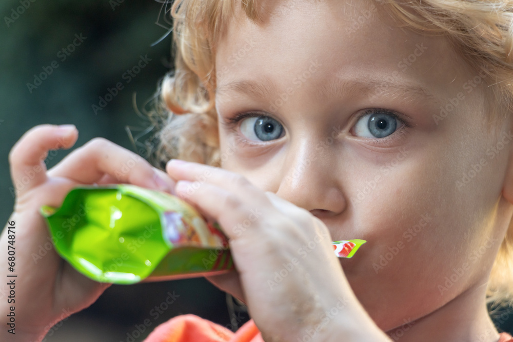 Portrait of a boy drinking liquid food from a small bag Portrait of a boy drinking liquid food from a small bag