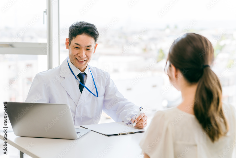 Fototapeta premium 診察・診療・問診・カウンセリングをする医者・医師・ドクターの男性と女性