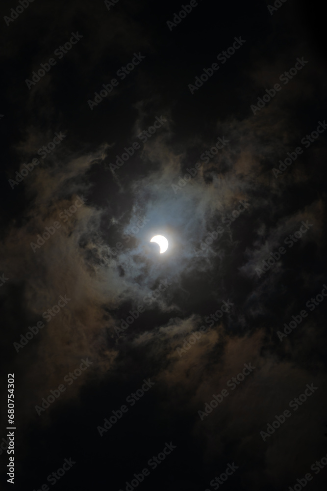 Dark landscape background of cloudy sky with solar eclipse in the center