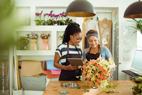 Florists collaborate over digital designs in a flower shop