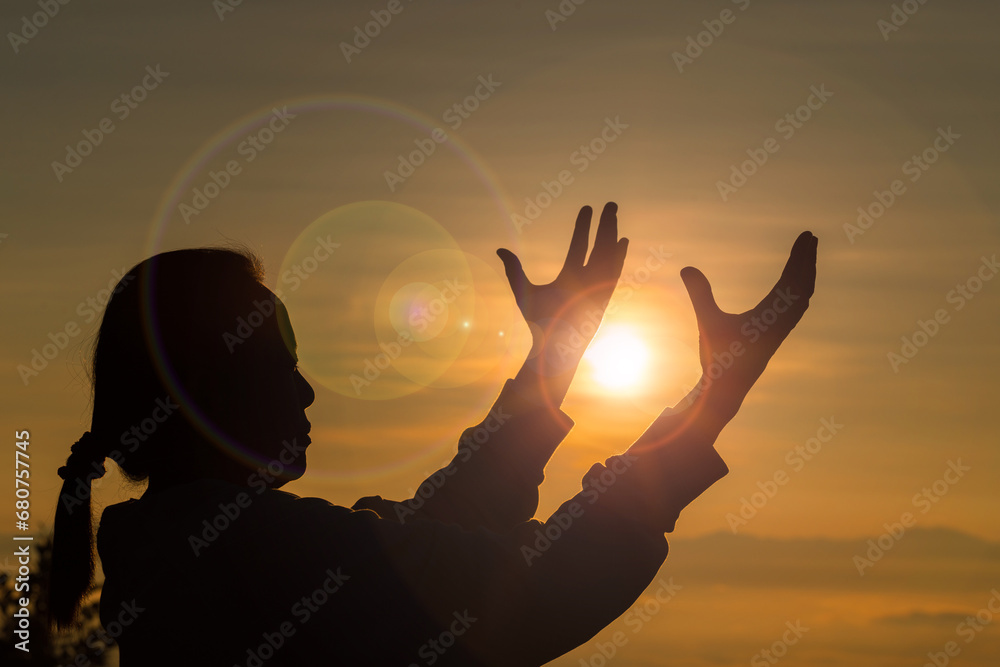 Silhouette woman on sunset background. Woman raising his hands in worship. Christian Religion concept background. Person hands open palm up worship. God helping repent catholic easter lent mind pray.