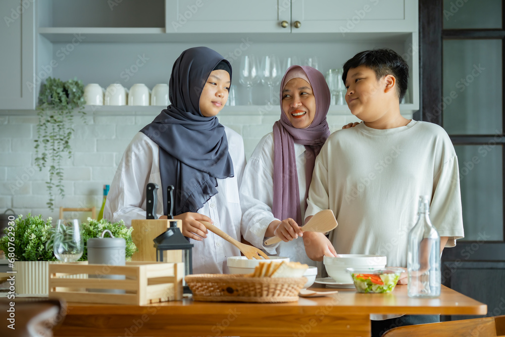 Cute Girl and Son and Her Muslim Mom In Hijab Preparing Pastry For Cookies In Kitchen, Baking Together At Home. Islamic Lady With Daughter and son Enjoying Doing Homemade Pastry Cute Girl and Son and Her Muslim Mom In Hijab Preparing Pastry For Cookies In Kitchen, Baking Together At Home. Islamic Lady With Daughter and son Enjoying Doing Homemade Pastry