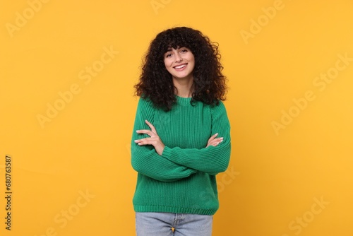 Happy young woman in stylish green sweater on yellow background photo
