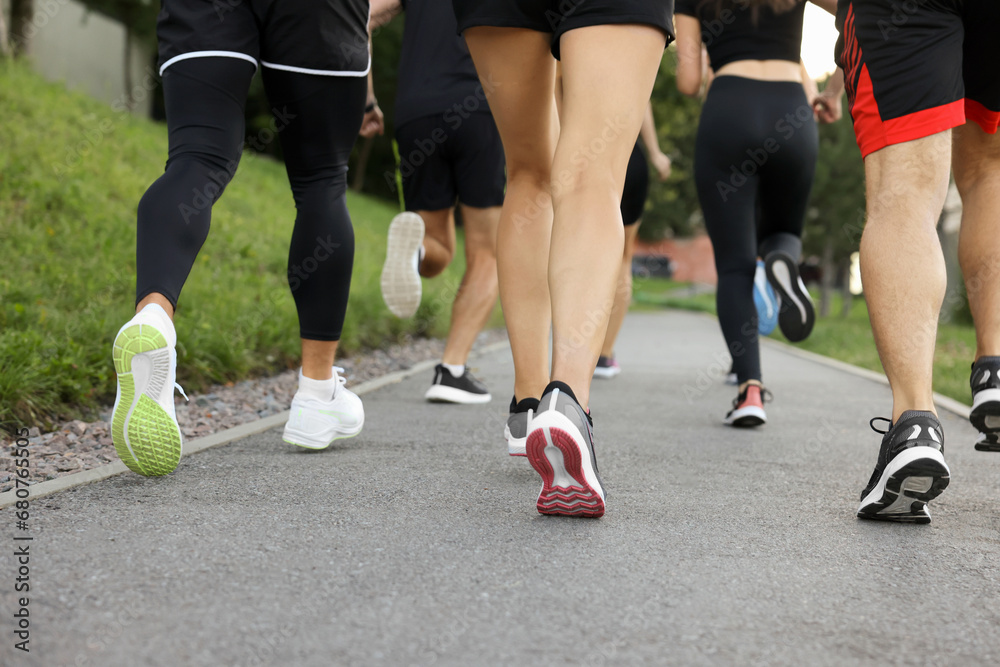 Group of people running outdoors, closeup view