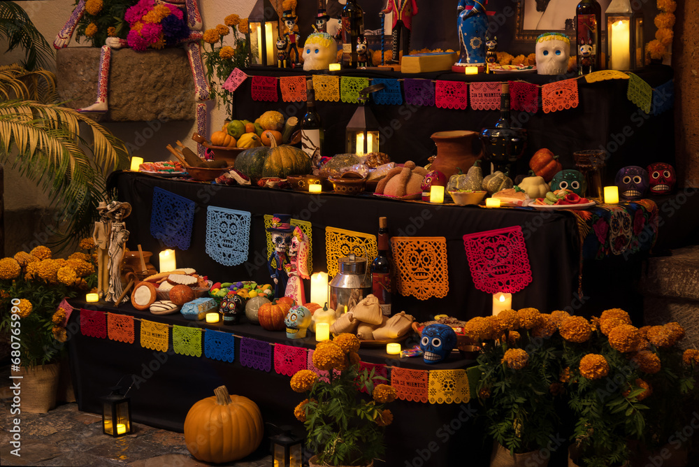 Day of the Dead altar with papel picadp, pumpkins, food and sweets