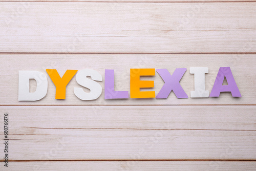 Word Dyslexia made of paper letters on wooden table, flat lay