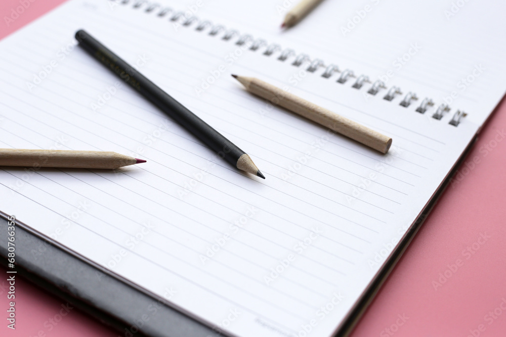 Notebook with pencils on pink background. Work planning Notebook with pencils on pink background. Work planning