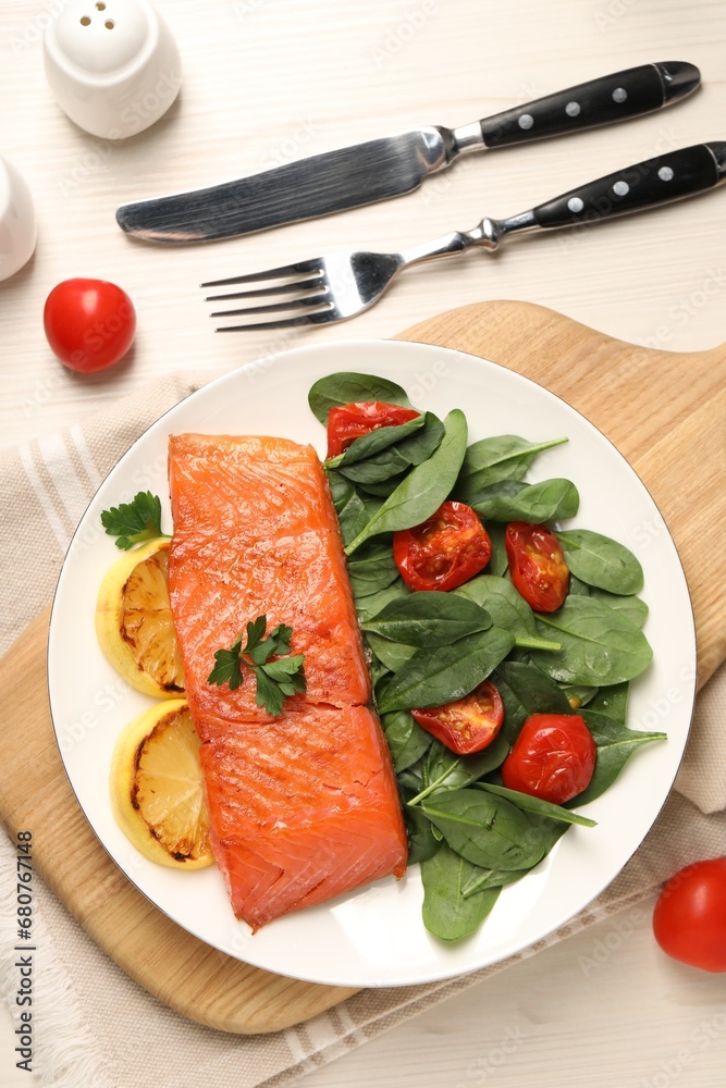 Tasty grilled salmon with basil, tomatoes and lemon on white wooden table, flat lay Tasty grilled salmon with basil, tomatoes and lemon on white wooden table, flat lay