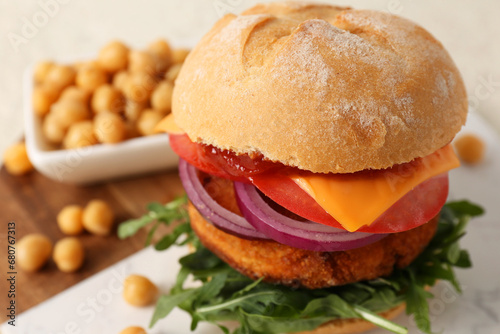 Tasty vegetarian burger with chickpea cutlet on white table, closeup