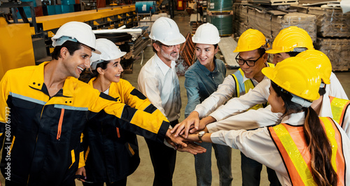 Cohesive and race diversity group of factory worker joining hands together in heavy steel industry factory exemplifying teamwork on diverse industrial engineering profession with team building concept