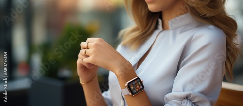 Young woman with smart watch on the background of a flower garden