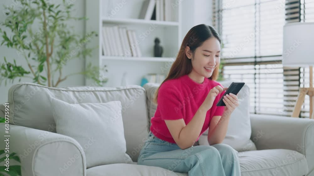 Happy young asian woman relax on comfortable couch at home texting messaging on smartphone, smiling girl use cellphone chatting, online shopping at home, video call communication Happy young asian woman relax on comfortable couch at home texting messaging on smartphone, smiling girl use cellphone chatting, online shopping at home, video call communication