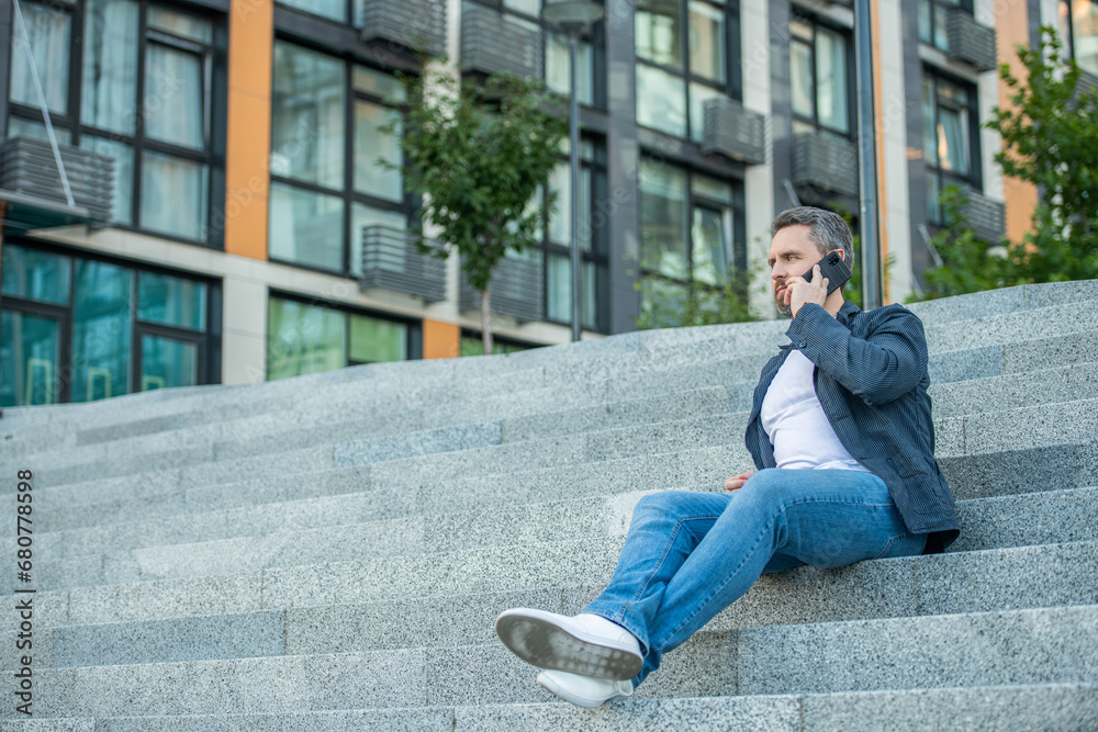 man has smartphone call outdoor, copy space. man having smartphone call in the street.