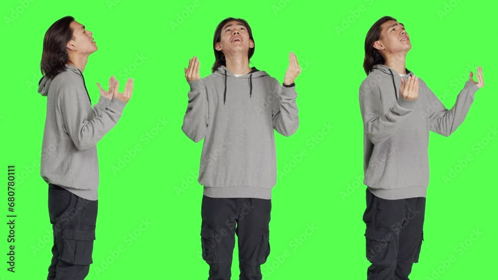 Model with belief praying to God against greenscreen studio backdrop, hoping for fortune and good things. Young religious man acting spiritual with prayer, feeling hopeful. Model with belief praying to God against greenscreen studio backdrop, hoping for fortune and good things. Young religious man acting spiritual with prayer, feeling hopeful.