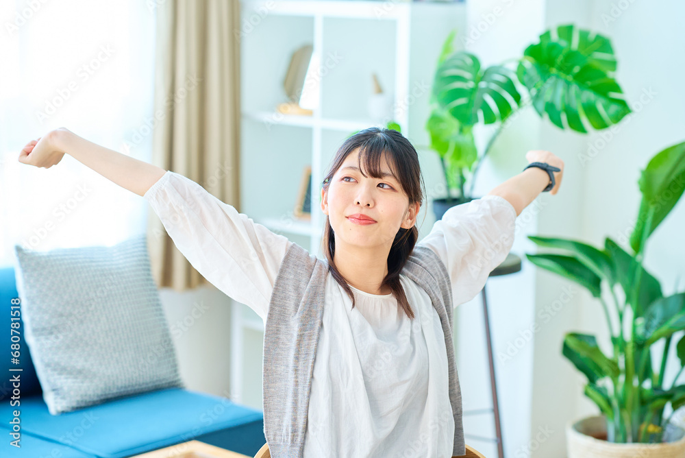 カジュアルな空間で深呼吸する若い女性