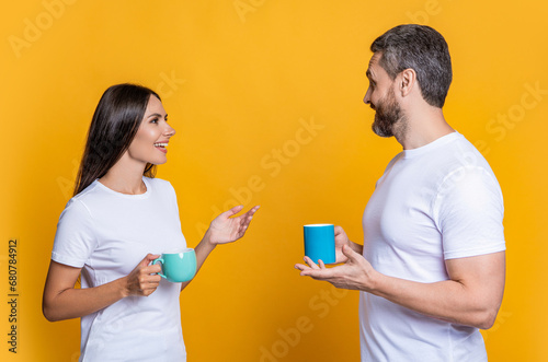 Family couple having coffee isolated on yellow. Morning coffee time. Couple of man and woman drinking tea. Family day together. Warm relationship. Coffee break at home. Ask about day