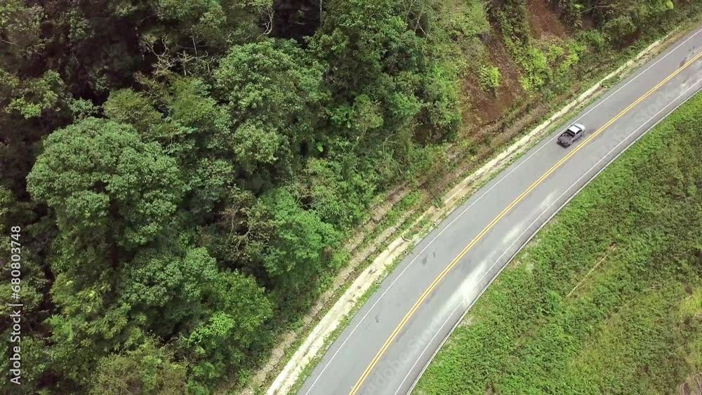 Aerial logistics concept. A winding road traverses the vibrant tropical rainforest, creating a mesmerizing blend of nature and transportation. A synergy of greenery and logistics in this captivating f Aerial logistics concept. A winding road traverses the vibrant tropical rainforest, creating a mesmerizing blend of nature and transportation. A synergy of greenery and logistics in this captivating f