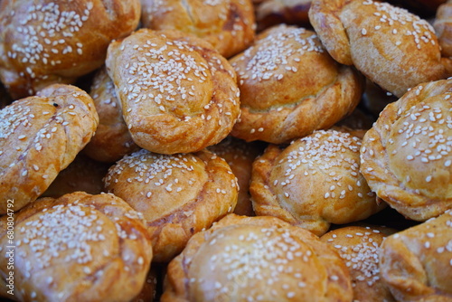 Puff pastry samosa with meat filling and sesame seeds.