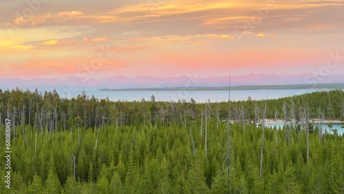 Lake Yellowstone National Park West Thumb Geyser Basin Grant Village stunning late autumn fall peaceful pink orange warm hue sunsets dusk green pines Teton National Forest cinematic pan right slowly photo