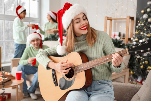 Young woman playing guitar ...