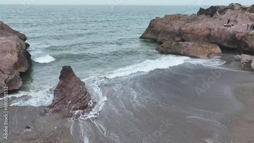 Aerial drone rotating shot over beautiful waves crashing on rocky beaches of Gadani, Pakistan during evening time. photo