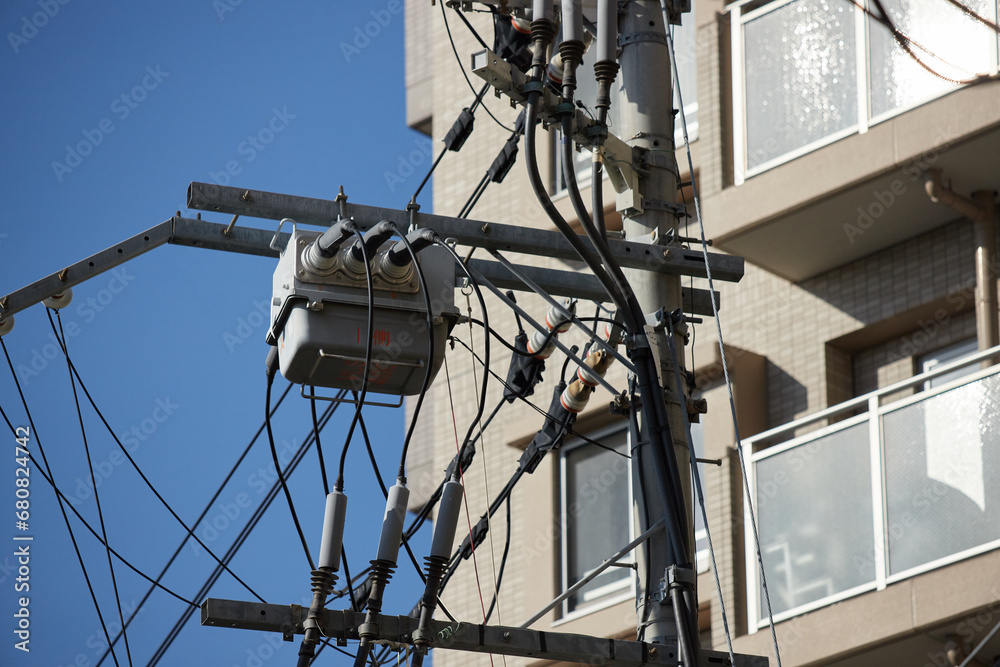 マンションのビルと町の電柱と電線の風景