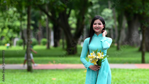 A young girl wearing a jade-green ao dai the traditional costume of Vietnam. Photo for tourism, culture, tradition, and the beauty of Asian people. Idea for train model in computer vision systems