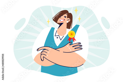 Woman with medal for best employee of month stands with arms crossed and looks at camera with smile