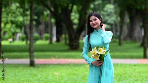 A young girl wearing a jade-green ao dai the traditional costume of Vietnam. Photo for tourism, culture, tradition, and the beauty of Asian people. Idea for train model in computer vision systems