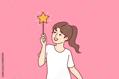 Little girl dreams of becoming fairy and waves magic wand, casting spells from fairy tales. Child wants to enroll in school of magic from fantasy stories about young sorcerers or witches