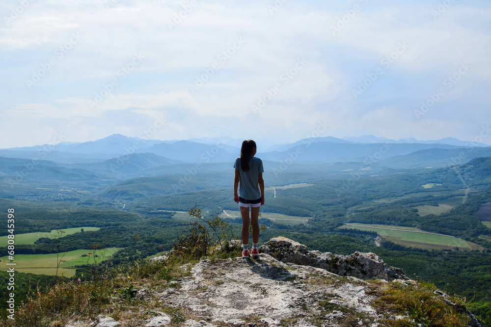 Tourist girl contemplates the mountain landscape Tourist girl contemplates the mountain landscape