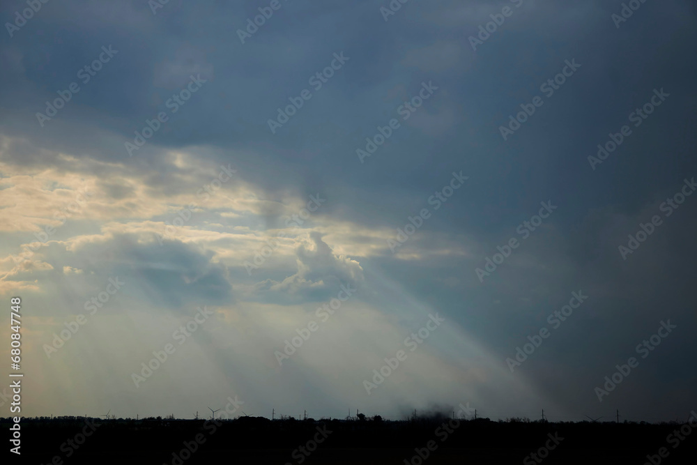 Landscape with the texture of clouds closer to sunset. The rays of the sun through the clouds. The nature of the central part of Eurasia.