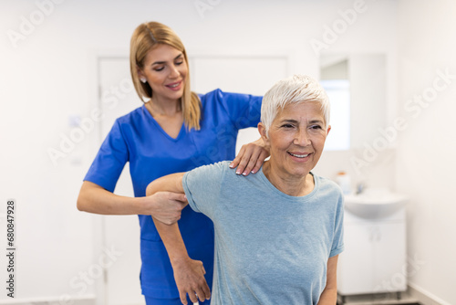 Doctor or Physiotherapist working examining treating injured arm of senior patient  stretching and exercise  Doing the Rehabilitation therapy pain in clinic.