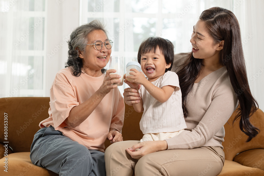 Happiness of Asian baby infant grandmother and mother enjoy drinking milk together at warmth place. Heartwarming scene of intergenerational joy share a delightful moment. Family Concept Happiness of Asian baby infant grandmother and mother enjoy drinking milk together at warmth place. Heartwarming scene of intergenerational joy share a delightful moment. Family Concept