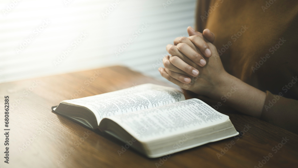 Naklejka premium Pray worship and read the Bible God at the table in church on Sunday mornings. Christian women hold Hand prayer and confession at home