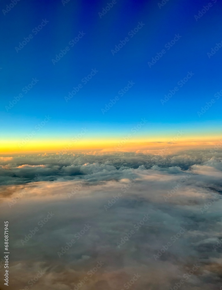 Blick aus dem Flugzeug Fenster über den Wolken mit Sonnenuntergang 
