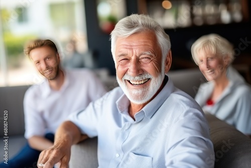 Old male friends of different races laugh remembering times and events sitting on couch in living room of apartment. Positive emotions and lifelong friendship. Laughing at joke with acquaintances