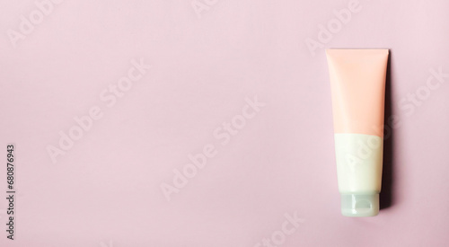 A clean label facial or body cream tube is isolated on a pink background. Beauty product mockup. Wellness packaging. Banner for Branding