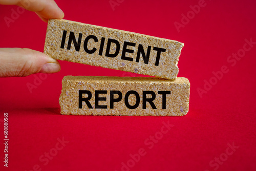 Security and insurance concept. Brick blocks with the inscription - Incident report on beautiful red background. Businessman hand. Copy space.