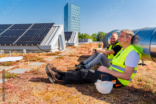 Two solar panel technicians taking a well-deserved break on the rooftop of a corporate building photo