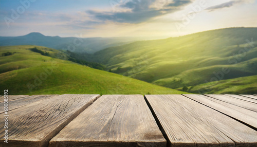 Wooden table in front of blurred green hills with cloudy sky. For product showing