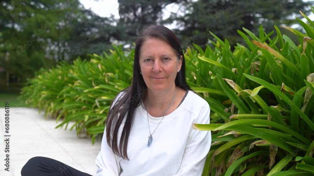 Adult Woman Looking At Camera While Resting In The Garden. medium shot Adult Woman Looking At Camera While Resting In The Garden. medium shot